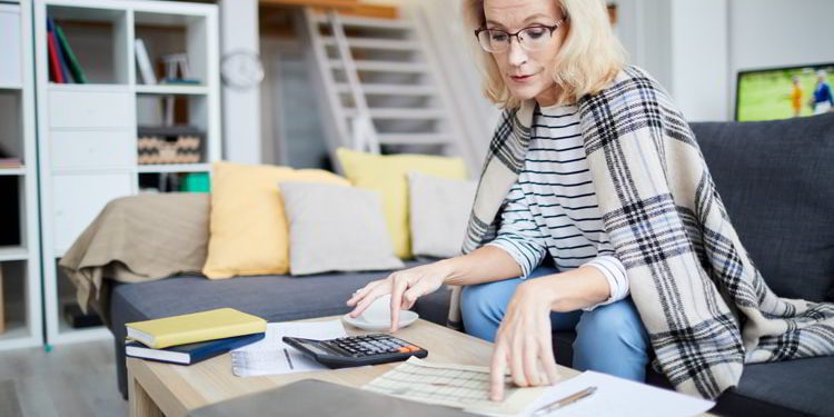 Portrait of contemporary mature woman calculating taxes