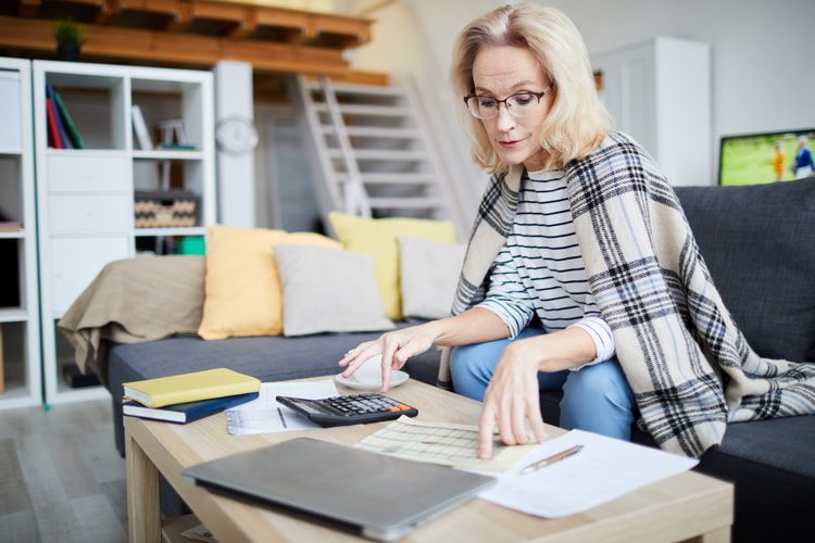 Portrait of contemporary mature woman calculating taxes