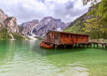 View of the boat house on the famous Lake Braies with emerald water in Italy. Home Exchange