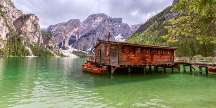 View of the boat house on the famous Lake Braies with emerald water in Italy. Home Exchange