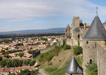 a stone wall and homes in carcassone france