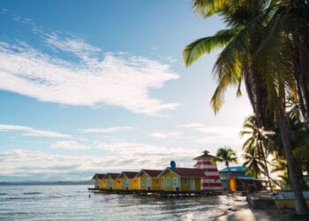 Picturesque view of small colorful houses on tropical coastline with palm trees, Panama.