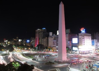 time lapse image of cars driving past an Obelisk monument at night in Buenos Aires