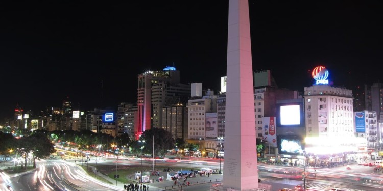 time lapse image of cars driving past an Obelisk monument at night in Buenos Aires