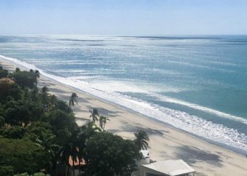 Blue skies and white and black sand beach in Coronado, Panama