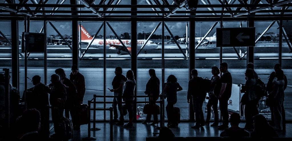 silhouette of people waiting in line at an airport terminal