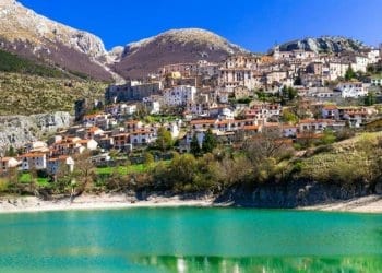 Abruzzo. Italy. italian town with mountains in background green water in front