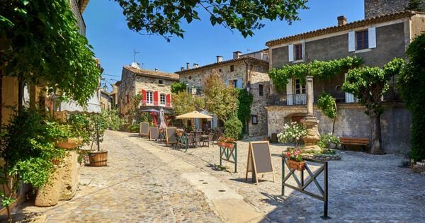 cidade tranquila em occitanie. um pequeno café com mesas no exterior