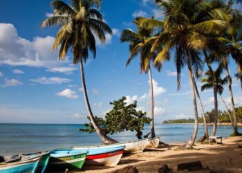 An empty beach with colorful boats on the sand in Las Terrenas, Dominican Republic.