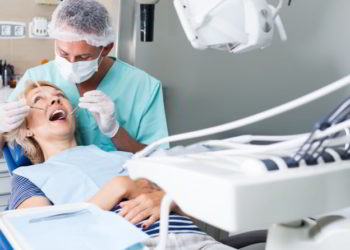 Male dentist treating female patient