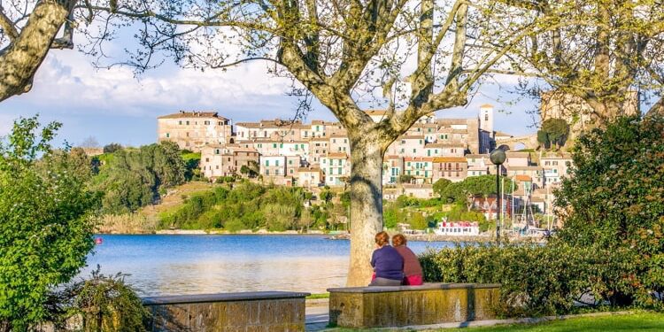 Ladies chatting on river shore in Italy.