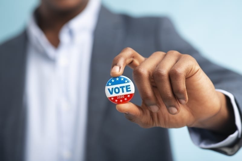 Man holding vote button.