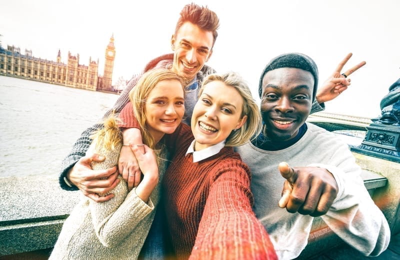 Happy friends group taking selfie in London