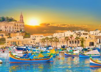 Marsaxlokk bay harbour of Malta, with beautiful architecture and boats at dusk