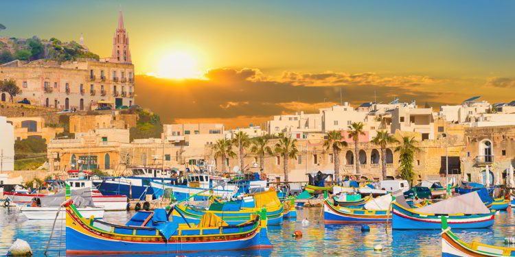 Marsaxlokk bay harbour of Malta, with beautiful architecture and boats at dusk