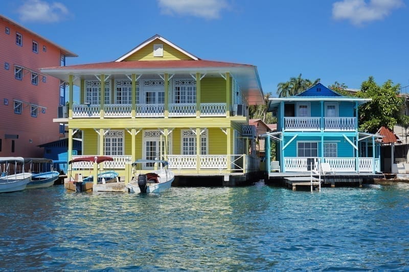 Typical Caribbean colonial homes over the water with boats at dock, Panama. 