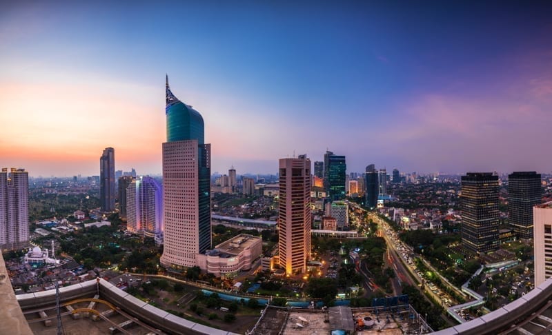 kolorowa Panorama Dżakarty o świcie z kultowym budynkiem. Budynek jest jednym z najwyższych budynków w Indonezji.