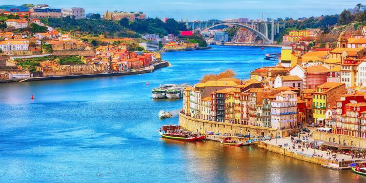 Porto, Portugal old town ribeira aerial promenade view with colorful houses, Douro river and boats