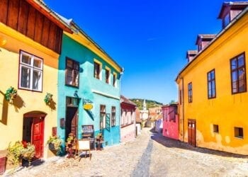 Famous stone paved old streets with colorful houses in Sighisoara, Romania.