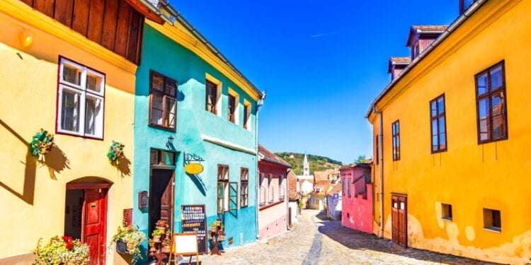 Famous stone paved old streets with colorful houses in Sighisoara, Romania.