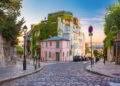 Cozy old street with pink house at the sunny sunrise, quarter Montmartre in Paris, France