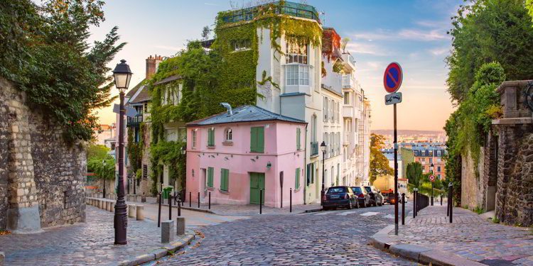 Cozy old street with pink house at the sunny sunrise, quarter Montmartre in Paris, France