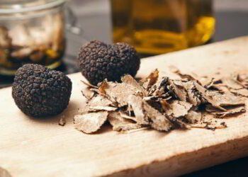 Two truffles and truffle shavings on a cutting board