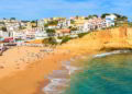 View of beach with in Carvoeiro town with colorful houses on coast of Portugal