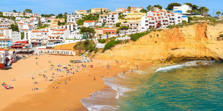 View of beach with in Carvoeiro town with colorful houses on coast of Portugal