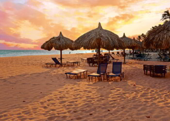 Beach umbrella's on Druif beach at Aruba island in the Caribbean at sunset