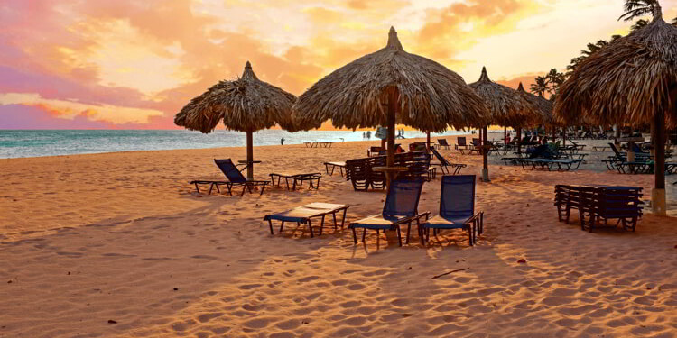 Beach umbrella's on Druif beach at Aruba island in the Caribbean at sunset