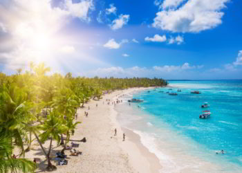 People enjoying a tropical Caribbean beach with white sands and clear waters