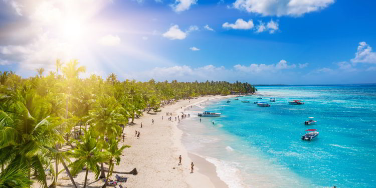 People enjoying a tropical Caribbean beach with white sands and clear waters