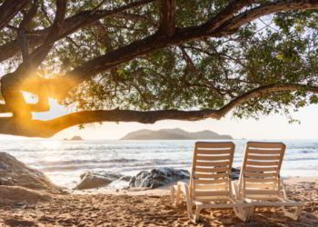 Beach chairs facing the sea at sunset in Zihuatanejo, Mexico