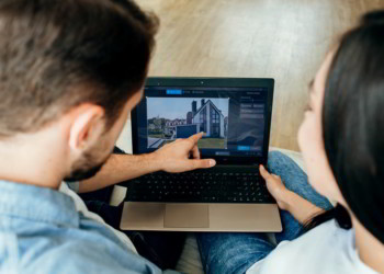 Couple choosing new house using laptop