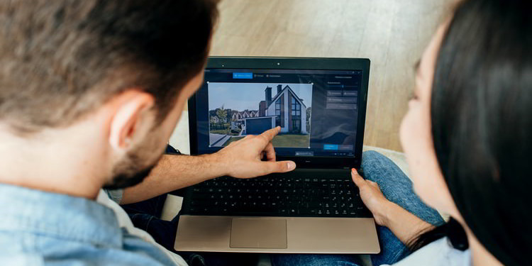 Couple choosing new house using laptop