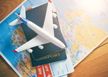 Plane model with world map, passports and tickets as airplane traveling and tickets booking concept