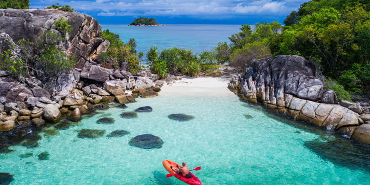 Aerial drone view of in kayak in crystal clear lagoon sea water during summer day near Koh Lipe island in Thailand