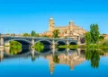 Cathedral at Salamanca reflected viewed behind bridge of enrique esteven on river Tormes, Spain