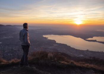 Hiker looking sun over horizon