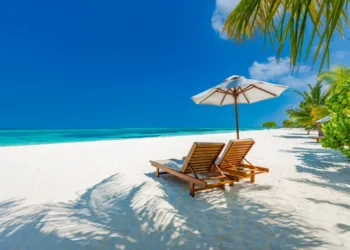 Luxury beach resort, beach loungers near the sea with white sand over sea Topical island. wealth strategy