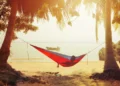 A person is enjoying the sunset in front of the sea.