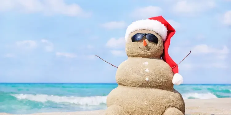 Tropical beach and snowman figure made with sand