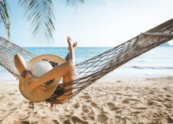 Traveler woman relaxing in hammock on summer beach Thailand