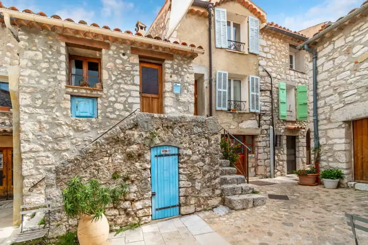 A picturesque garden courtyard and alley in the medieval stone hilltop village of Gourdon in the Alpes-Maritimes mountains of Southern France.