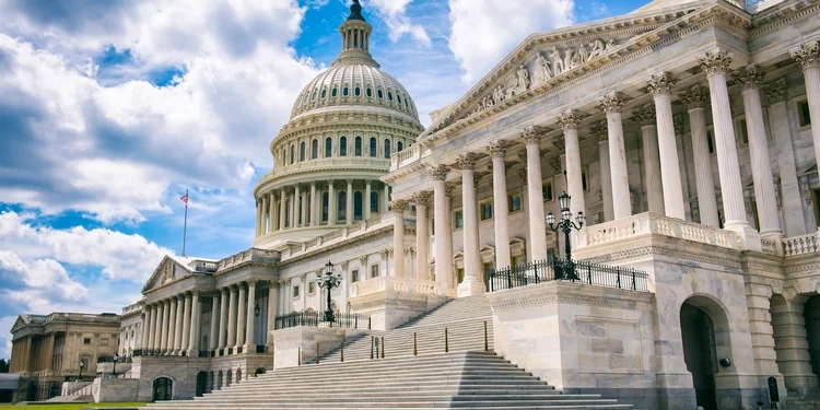 Bright mid-day view of the Capitol Building’s dome, columns, and steps in Washington DC