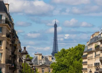 Eiffel tower between Parisian tenement old street alley and buildings