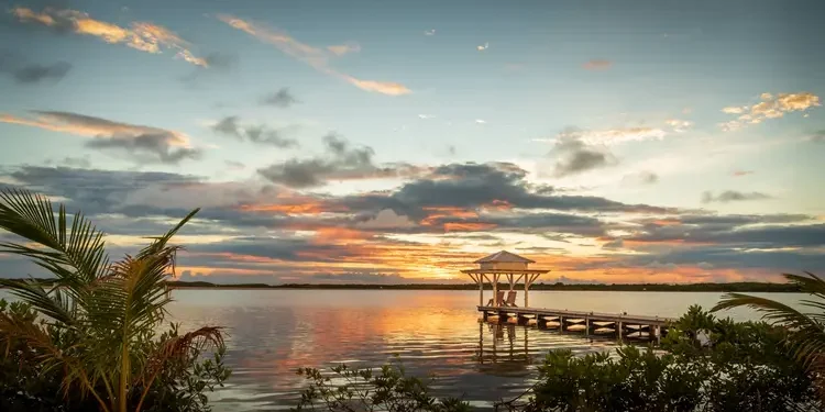 Sunset view of a pier with a bungalow in the Caribbean. choose to retire in the Caribbean