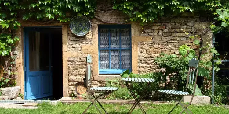 Sunny day in a cottage garden with chairs and table