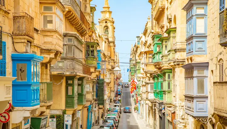 Narrow street with colorful balconies in Valletta old town. climate in malta